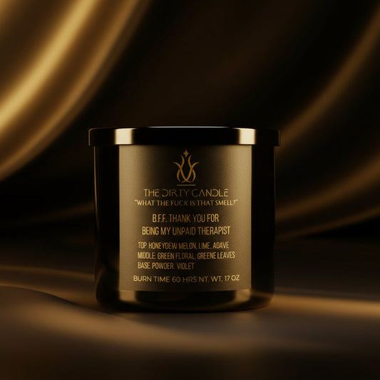 Black candle with gold text on a dark background
